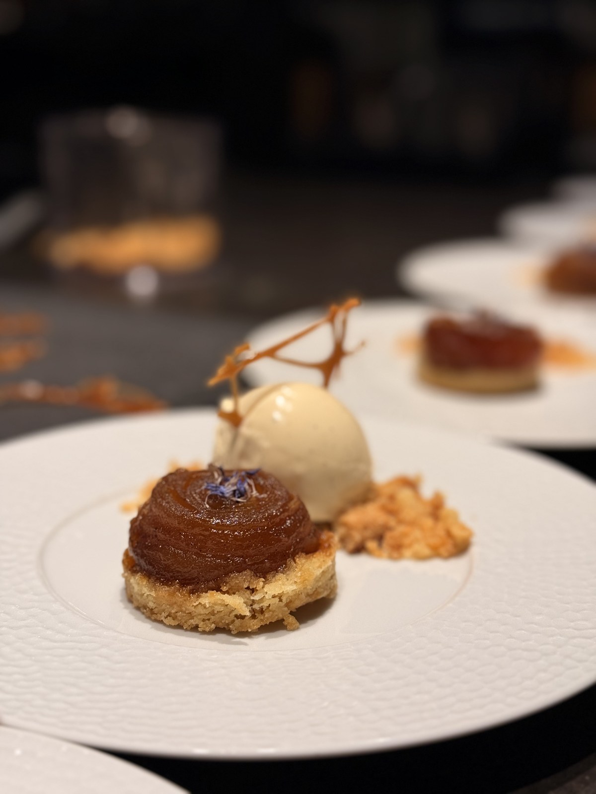 Karamellisiertes Tarte-Dessert mit Vanilleeis auf weissem Teller bei K wie Kochkunst