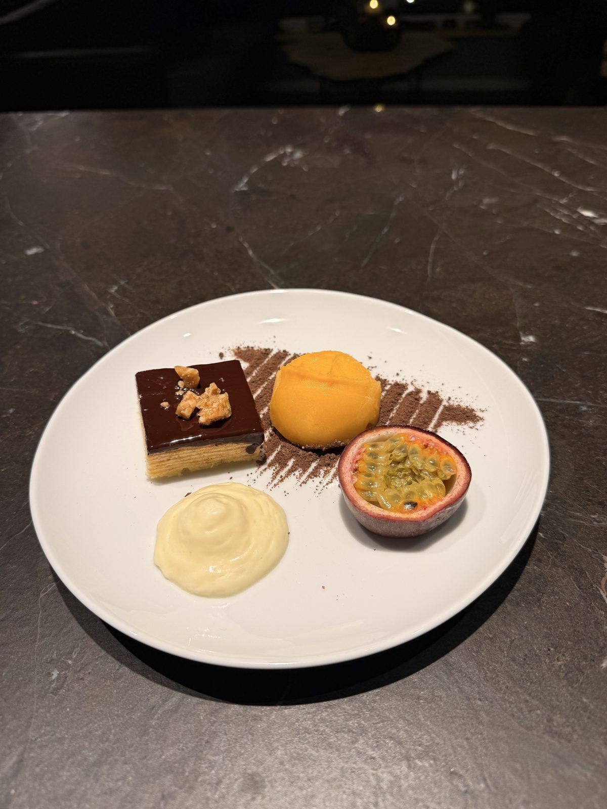 Dessertteller mit Schokoschnitte, Mangosorbet und halbierter Passionsfrucht bei K wie Kochkunst