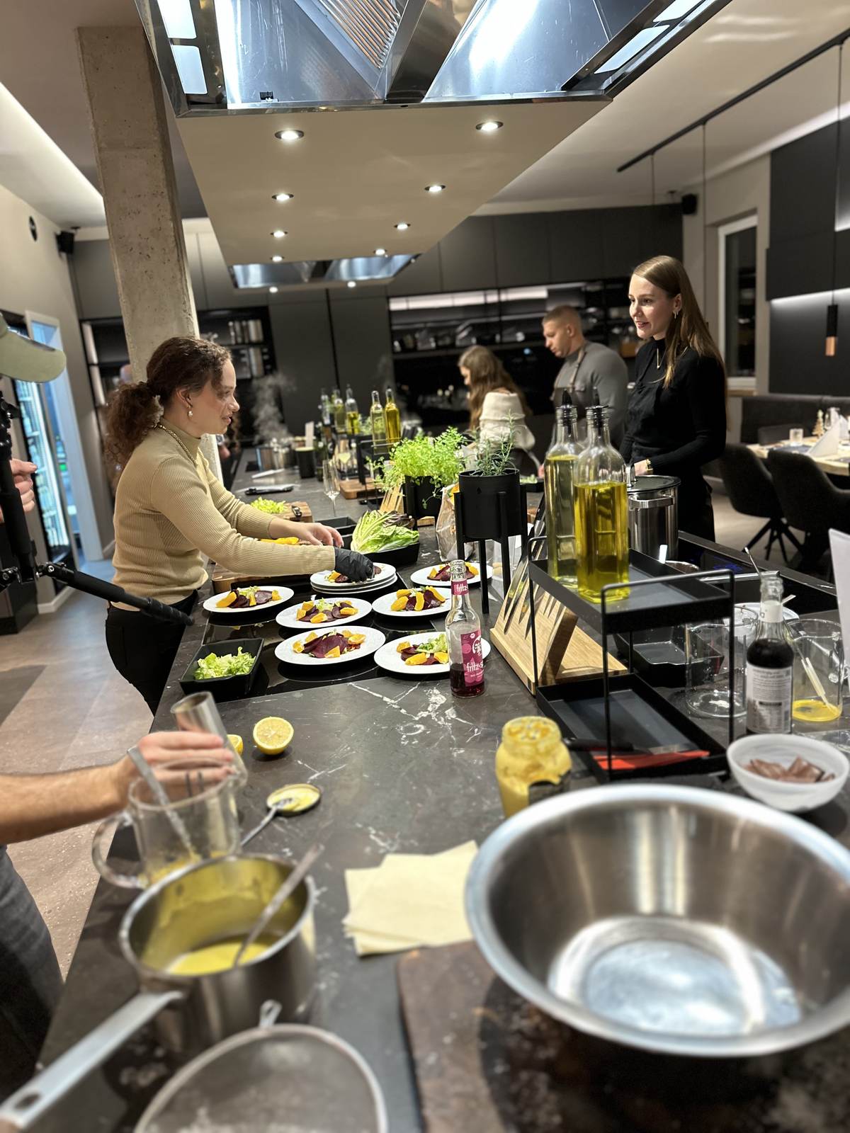 Gaeste richten Teller an einer Live-Cooking-Station von K wie Kochkunst an