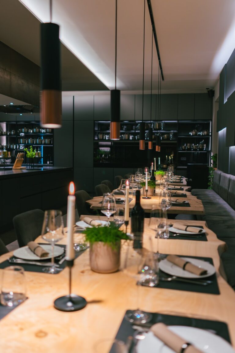 hochzeit & kleine hochzeitsfeier paderborn — kochkurs eventlocation 15 Lange eingedeckte Tafel mit Kerzen im dunklen Kochstudio der Eventlocation Paderborn